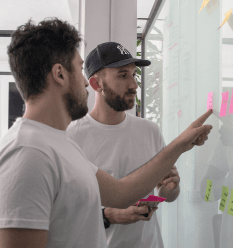 Two designers using posts it on a wall